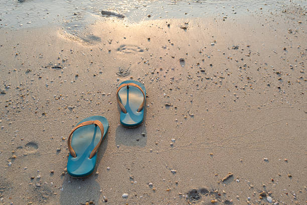 istock slippers on the sand beach background at sunset 584890778