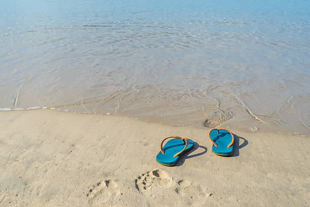 istock Green slippers with the sand beach in Phuket Thailand 584891012