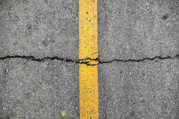 Photo of Crack on line yellow on road textured