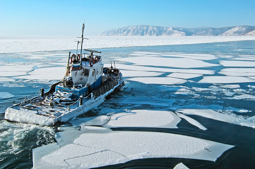 Departing ship among the ice floes on lake Baikal in Listvyanka.The mouth of the Angara.