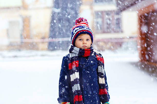 istock Happy kid boy having fun with snow in winter 585046382