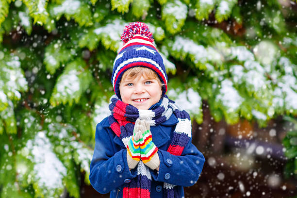 istock Happy kid boy having fun with snow in winter 585046680
