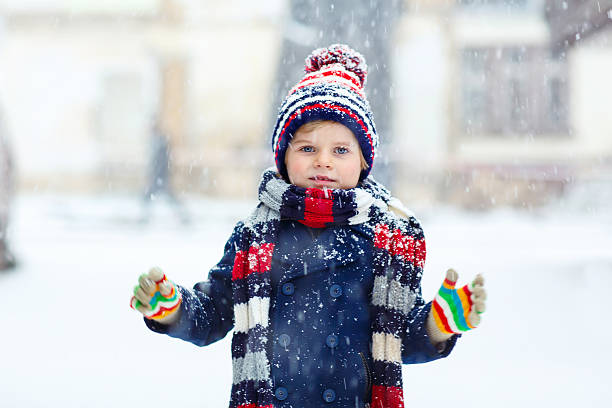 istock Happy kid boy having fun with snow in winter 585046724