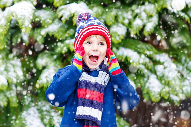 istock Happy kid boy having fun with snow in winter 585047326
