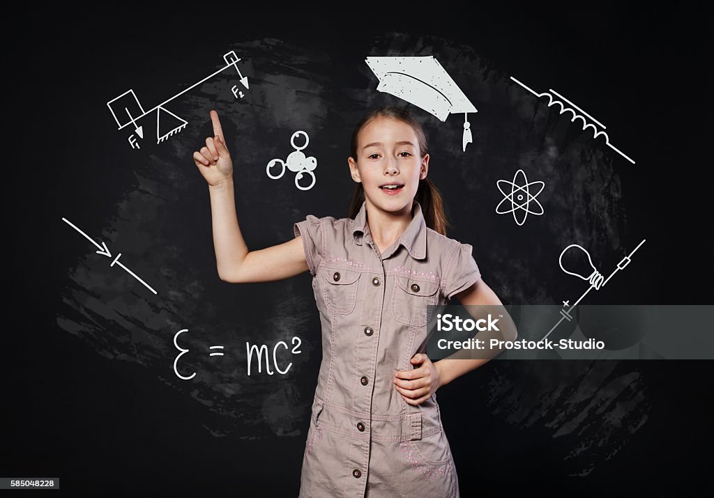 Kleines Mädchen hat Idee in der Nähe von Tafel. Kind zeigt Finger nach oben - Lizenzfrei Akademischer Abschluss Stock-Foto