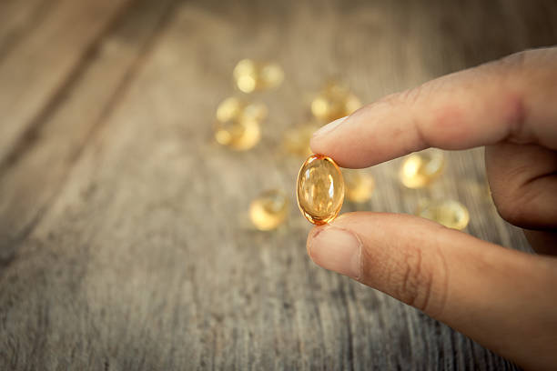 istock Woman hold Cod liver oil omega 3 gel capsules 585049108