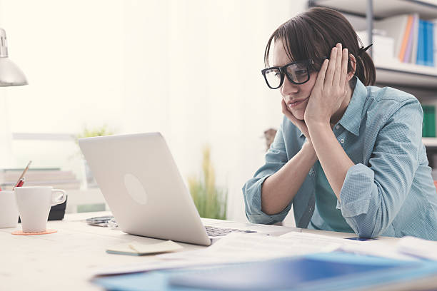 istock Bored woman working with her laptop 585049820