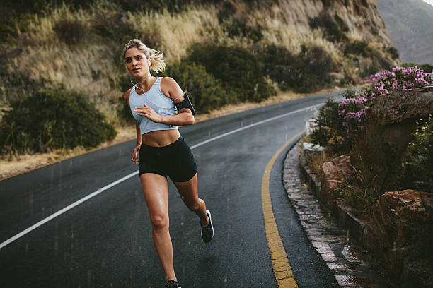 istock Female athlete running along the highway 585051042