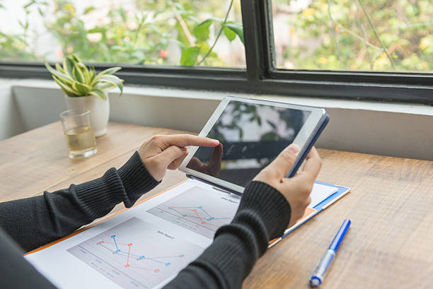 istock Woman using tablet for showing the sales report data 585052034