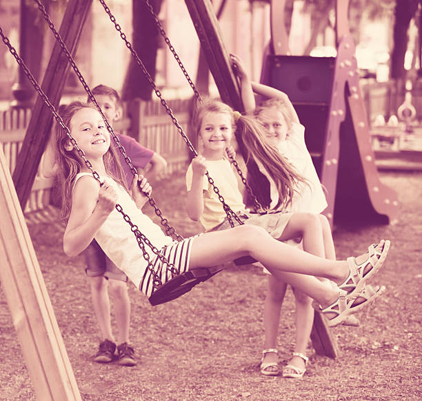 istock Small happy kids  swinging on playground 585053924