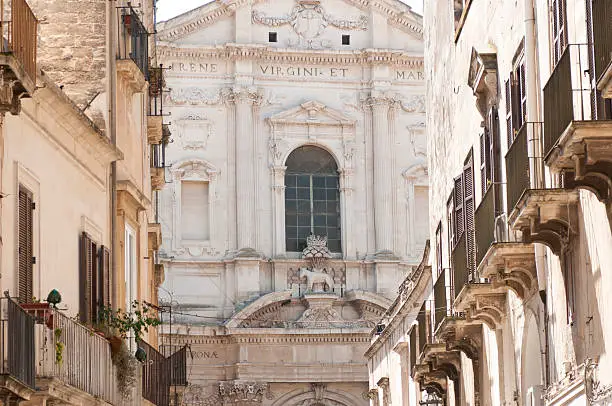 Glimpse of a way of the facade of the baroque church of St. Irene in Lecce