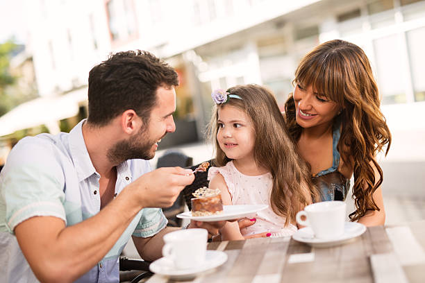 istock Young loving family having fun in a cafe eating cake. 585056420