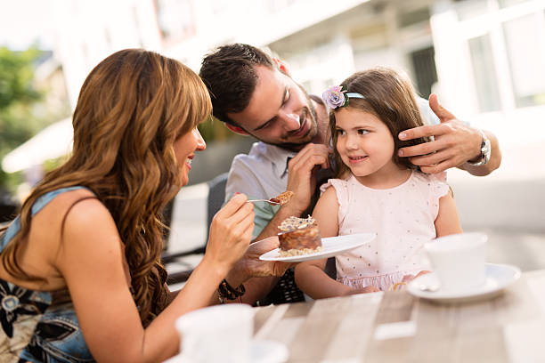 istock Young loving family having fun in a cafe eating cake. 585056914