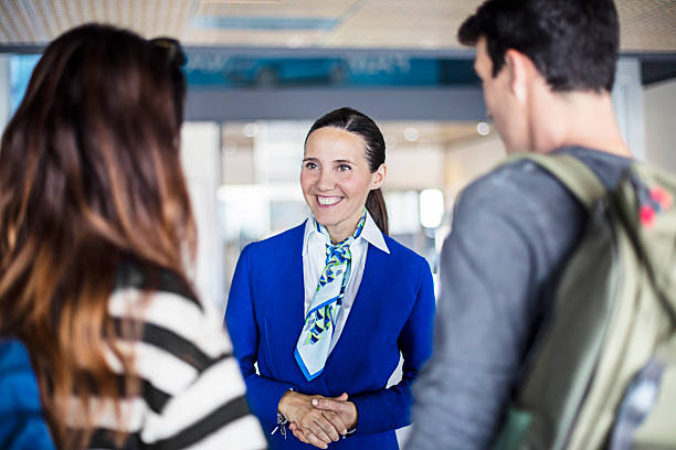 Air hostess helping young couple at airport Air hostess helping young couple at airport. air stewardess stock pictures, royalty-free photos & images