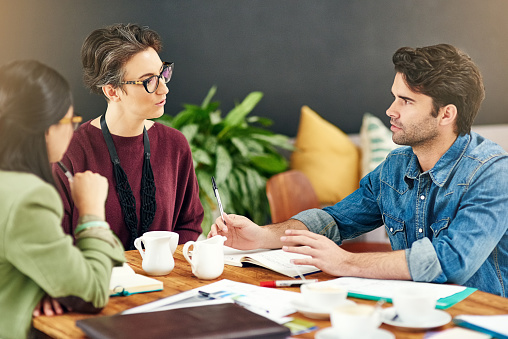 Cropped shot of a group of young creatives having a meeting in a modern office