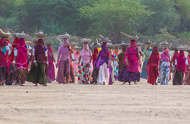 Rajasthan, India - November 16, 2015: Women from Rural Rajasthan returning after work. Indian Goverment has started a program MGNREGA ( Mahatma Gandhi National rural employment guarantee act) is designed to provide job guarantee for at least 100 days in rural parts of the country. through this scheme all the adult members of the any family in rural part of the country are given non-skilled work. 