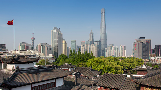View of the Pudong; the financial district of Shanghai. Seen over the traditional Chinese rooftops of the old town center. At the Pudong the famous skyscrapers; Shanghai Tower, Oriental Pearl Tower, Jin Mao Tower and the Shanghai World Financial Center can be seen.