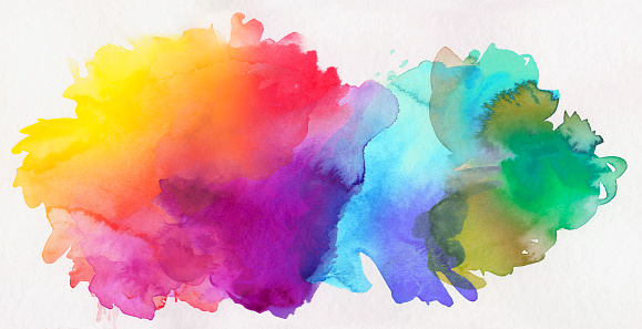 bright rainbow colored watercolor paints on white paper