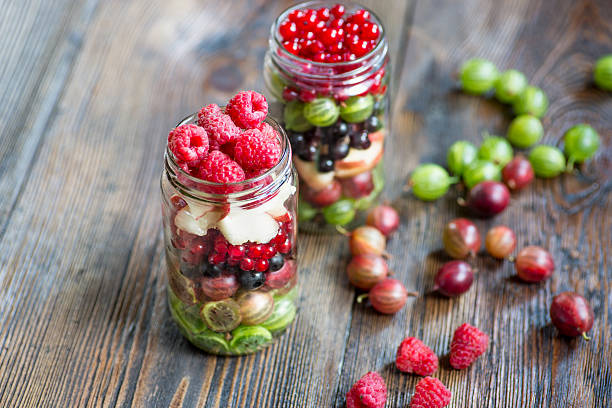 summer berries smoothie in mason jar on rustic wooden table - blueberry smoothie milk shake drink imagens e fotografias de stock