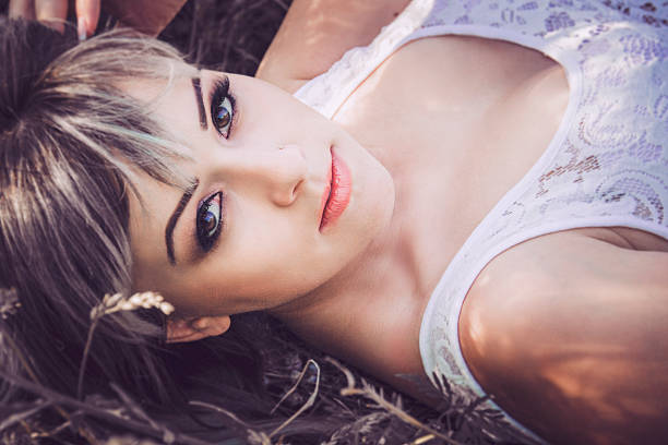 A beautiful young woman lying on the grass. Beautiful eyes close up.