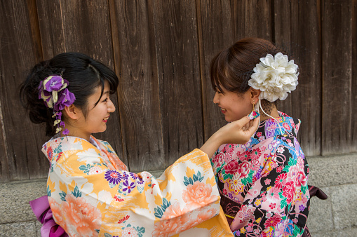 girls wearing kimono costume chat eachother at street of  kyoto japan