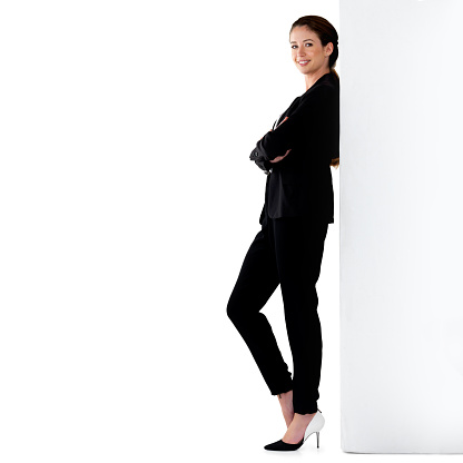 Studio portrait of a successful young businesswoman leaning against a wall