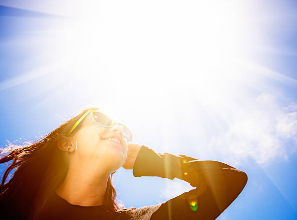 il sole splendente abbaglia la bella bruna con gli occhiali da sole - strizzare gli occhi foto e immagini stock