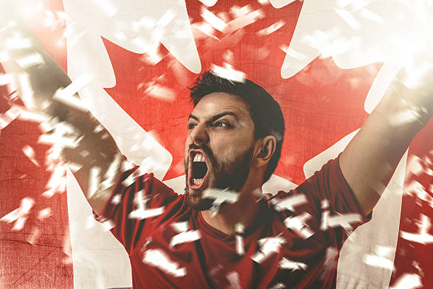 atleta celebrando y sosteniendo la bandera de canadá - canadian football fotografías e imágenes de stock