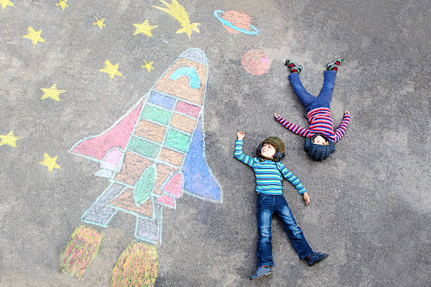 istock Two little kid boys flying by space shuttle chalks picture 585075384