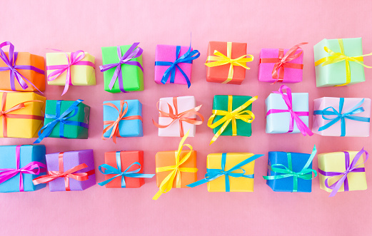 Many colorful gifts wrapped in bright paper with little ribbons