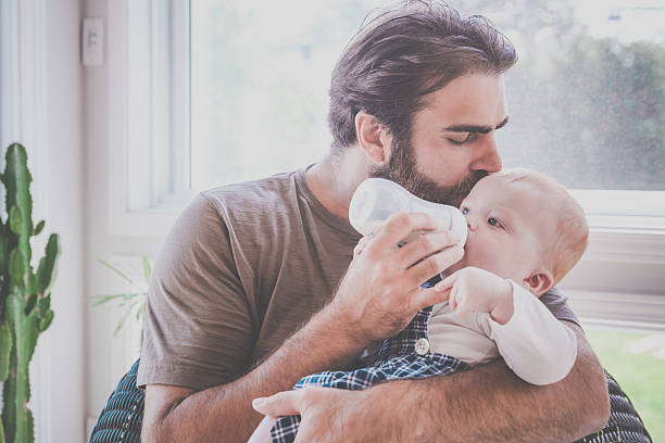 istock Modern Dad Feeding his Baby Boy with Milk Bottle 585076998
