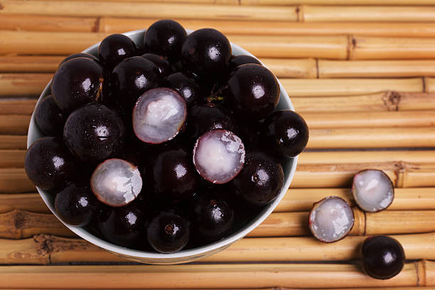 berry jaboticaba in ciotola su tavolo di bambù - fruit table bamboo black foto e immagini stock