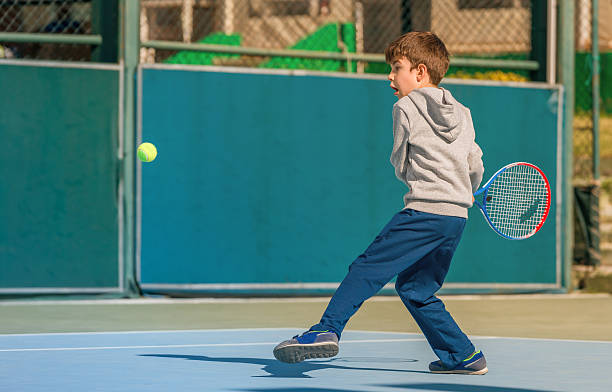 istock young boy play tennis 585084412