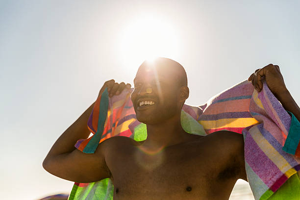 istock Happy man with beach towel on sunny day 585084868