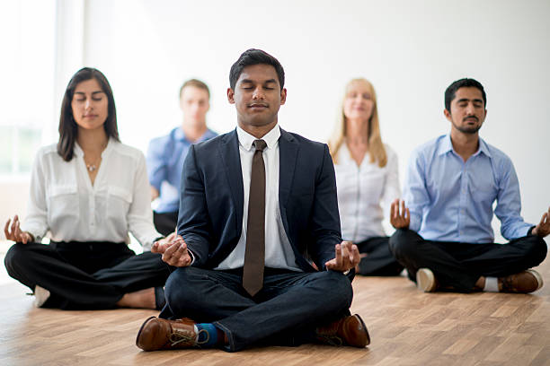 business professionals meditating together - yoga meditating business group of people imagens e fotografias de stock
