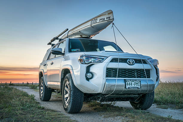 Toyota 4Runner SUV with canoe on roof Castle Rock, Ks, United States - July 25, 2016: Toyota 4Runner SUV (2016 Trail edition) with a canoe (Sea Wind by Kruger Canoes) on roof racks driving during summer vacations on Kansas  back country roads Castle Rock stock pictures, royalty-free photos & images