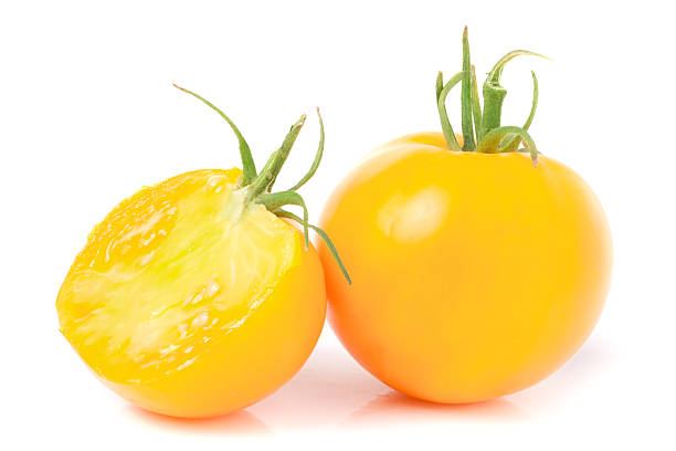 istock yellow tomato with half isolated on white background 585087992