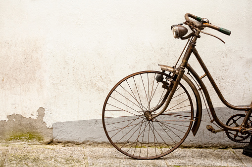 Rusty old bicycle leaning on a wall.