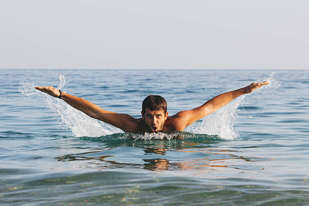 istock Young hansome man swimming buterfly style 585090640