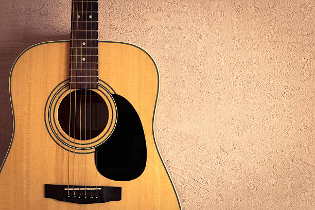 istock acoustic guitar on beige background vintage wall 585092230