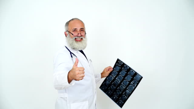 adult senior doctor looks picture MRI of the head and showing a thumbs up on a gray background