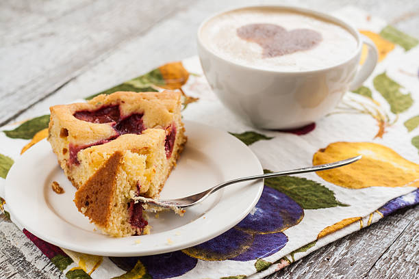 istock pie with plums and slice and cup with coffee 585146104