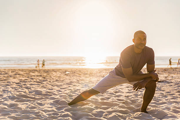 happy man stretching at beach on sunny day - stretch beach imagens e fotografias de stock