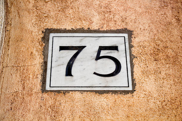 istock Engraved old building number 75 in Rome 585148582