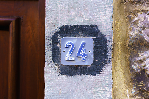 house number twenty four embossed in a small metal plate.