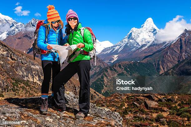 Photo libre de droit de Jeune Femme Étudie Carte Dans Lhimalaya Le Parc National Du Mont Everest banque d'images et plus d'images libres de droit de Activité de plein air