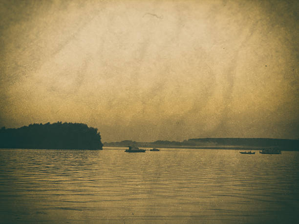 Four boats meet at the confluence, at dusk. Image is treated like an old photo