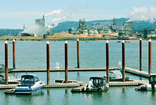 Native Americans fishing for salmon in Columbia River between lumber mill in Washington state and marina in Rainier OR