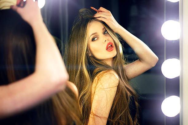 istock Woman looking into makeup mirror at herself. 585153202