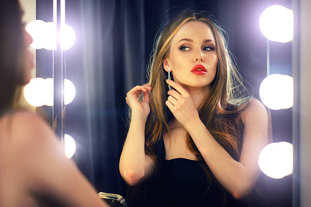 istock Woman looking into makeup mirror at herself. 585153352